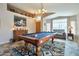Well-lit game room features a pool table, carpet, and comfortable seating at 11540 W Sonoran Ct, Surprise, AZ 85378