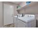 Convenient laundry room featuring modern appliances and ample shelving for storage at 11540 W Sonoran Ct, Surprise, AZ 85378