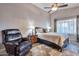 Bedroom with cozy chair, neutral colors, ceiling fan, and natural light from the window at 11540 W Sonoran Ct, Surprise, AZ 85378