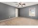 Bedroom with carpet flooring, ceiling fan and double-hung window, offering a cozy retreat at 11737 W Robin Dr, Sun City, AZ 85373