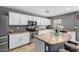 Bright kitchen featuring stainless steel appliances, a kitchen island, and white cabinets at 11737 W Robin Dr, Sun City, AZ 85373