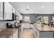 Well-lit kitchen with stainless appliances, white cabinets, tile floors and ample counter space at 11737 W Robin Dr, Sun City, AZ 85373