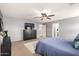 Serene main bedroom showcasing a ceiling fan, carpet, and dark-colored dresser with a mounted TV at 11737 W Robin Dr, Sun City, AZ 85373