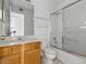Full bathroom with light wood vanity and shower and tub with sliding glass doors at 11815 N 75Th Ln, Peoria, AZ 85345