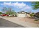 A well-maintained single-Gathering home with a spacious driveway, mature trees and desert landscaping under a sunny blue sky at 11815 N 75Th Ln, Peoria, AZ 85345