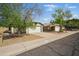 Cozy single-Gathering homes with a two-car garage, desert landscaping and mature trees under a clear blue sky at 11815 N 75Th Ln, Peoria, AZ 85345