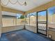 Enclosed porch area with blue carpeting, multiple pane windows and a screen door at 11815 N 75Th Ln, Peoria, AZ 85345