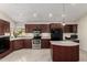 Bright kitchen featuring dark wood cabinets, stainless steel appliances and a center island at 12436 S 38Th Pl, Phoenix, AZ 85044