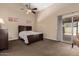 Bright main bedroom features a ceiling fan, carpet floors, and sliding glass doors to the back yard at 12436 S 38Th Pl, Phoenix, AZ 85044