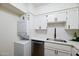 Updated laundry closet next to the stainless steel sink features all white cabinetry at 1302 E Maryland Ave # 15, Phoenix, AZ 85014