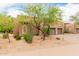 Neutral stucco exterior with stone accents, arched windows, mature trees, and manicured desert landscaping at 13300 E Via Linda -- # 1065, Scottsdale, AZ 85259