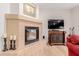 Living room fireplace adjacent to a TV and red sofa at 13300 E Via Linda -- # 1065, Scottsdale, AZ 85259