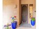 A welcoming front door with desert landscaping, potted plants, and a security screen door at 13300 E Via Linda -- # 1065, Scottsdale, AZ 85259