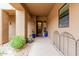 Inviting covered front porch with desert landscaping, potted plants, and a security screen door at 13300 E Via Linda -- # 1065, Scottsdale, AZ 85259