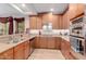Gourmet kitchen with wood cabinets, stainless steel appliances, granite countertops, and tile backsplash at 13300 E Via Linda -- # 1065, Scottsdale, AZ 85259