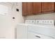 Bright laundry room with white appliances and cherry wood cabinets at 13300 E Via Linda -- # 1065, Scottsdale, AZ 85259