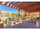 Community pool area under a wooden pergola with nearby stone benches and tables at 13300 E Via Linda -- # 1065, Scottsdale, AZ 85259