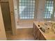 Bathroom with a large tub, glass block window, and a separate shower at 17705 N Larkspur Ln, Surprise, AZ 85374