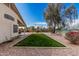 Landscaped backyard with artificial grass, patio, and gravel at 17943 N Woodrose Ave, Surprise, AZ 85374