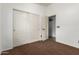 Carpeted bedroom with a double closet, and a door for easy access at 17943 N Woodrose Ave, Surprise, AZ 85374