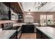 Modern kitchen featuring stainless steel appliances, dark cabinets, and ample countertop space at 17943 N Woodrose Ave, Surprise, AZ 85374