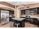Well-lit kitchen with stainless steel appliances, modern light fixture, and central island with counter seating at 17943 N Woodrose Ave, Surprise, AZ 85374