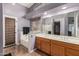 Bright bathroom with double sinks, tile floor, soaking tub, and large mirror at 17943 N Woodrose Ave, Surprise, AZ 85374