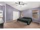 Spacious main bedroom with a ceiling fan, neutral carpet, and two windows for natural light at 17943 N Woodrose Ave, Surprise, AZ 85374