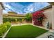 Private backyard featuring artificial turf, lush landscaping, and a charming patio area for outdoor enjoyment at 18502 N 98Th Way, Scottsdale, AZ 85255