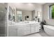 Elegant bathroom with double sinks, a large mirror, and a soaking tub for a spa-like experience at 18502 N 98Th Way, Scottsdale, AZ 85255