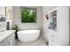 Relaxing bathroom with a freestanding tub, window view, and modern fixtures, creating a peaceful oasis at 18502 N 98Th Way, Scottsdale, AZ 85255