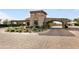 Elegant gated community entrance featuring stone archway, water fountain, and lush landscaping at 18502 N 98Th Way, Scottsdale, AZ 85255
