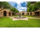 Beautiful courtyard featuring a large fountain, lush green lawn, and arched walkways at 18502 N 98Th Way, Scottsdale, AZ 85255