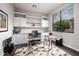 Bright home office with custom built-ins, a sleek glass desk, and a large window at 18502 N 98Th Way, Scottsdale, AZ 85255