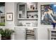Chic wet bar featuring a wine fridge, glass shelving, and stylish decor at 18502 N 98Th Way, Scottsdale, AZ 85255