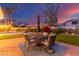 Inviting backyard featuring an outdoor dining area, lush lawn, and a picturesque sunset backdrop at 2040 E Indigo Brush Rd, Phoenix, AZ 85048