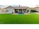 Expansive backyard featuring artificial grass, covered patio, and plenty of room for entertaining at 2040 E Indigo Brush Rd, Phoenix, AZ 85048