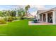 Well-maintained backyard with lush artificial grass, beautiful landscaping, and an outdoor dining area for entertaining at 2040 E Indigo Brush Rd, Phoenix, AZ 85048