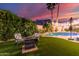 Well-maintained backyard with artificial grass, seating area, and mature landscaping at 2040 E Indigo Brush Rd, Phoenix, AZ 85048