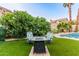 Outdoor seating area with a fire pit surrounded by artificial grass and lush landscaping for cozy evenings at 2040 E Indigo Brush Rd, Phoenix, AZ 85048