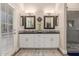 Elegant bathroom featuring double sinks, black countertops, white cabinets, and a glass-enclosed shower at 2040 E Indigo Brush Rd, Phoenix, AZ 85048
