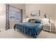 Comfortable bedroom with a blue quilt, bedside tables, decorative art, and plenty of natural light at 2040 E Indigo Brush Rd, Phoenix, AZ 85048