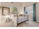 Bright bedroom featuring a wrought iron bed, decorative art, and a cozy seating area by the window at 2040 E Indigo Brush Rd, Phoenix, AZ 85048