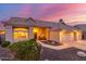 Charming single-story home featuring a well-manicured lawn and an attached two-car garage at twilight at 2040 E Indigo Brush Rd, Phoenix, AZ 85048