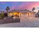 Beautiful home with a tile roof, three-car garage and desert landscaping under a pink and blue sky at 2040 E Indigo Brush Rd, Phoenix, AZ 85048