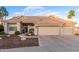 A lovely home with a three-car garage and tile roof is enhanced by desert landscaping and palm trees at 2040 E Indigo Brush Rd, Phoenix, AZ 85048