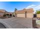Well maintained beige single-story home with a three car garage and desert landscaping at 2040 E Indigo Brush Rd, Phoenix, AZ 85048