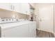 Laundry room features white appliances, cabinet storage, and a clean, organized layout at 2040 E Indigo Brush Rd, Phoenix, AZ 85048
