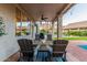 Covered patio boasts stylish seating and an outdoor dining area, ideal for enjoying the serene backyard views at 2040 E Indigo Brush Rd, Phoenix, AZ 85048