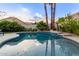 Backyard pool featuring meticulously landscaped gardens and trees, enhanced by ambient outdoor string lights at 2040 E Indigo Brush Rd, Phoenix, AZ 85048